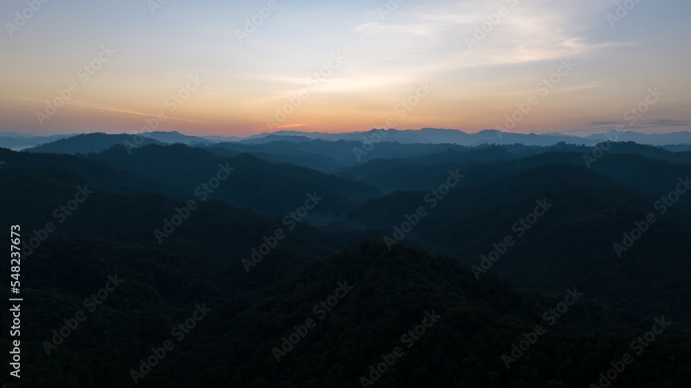 Landscape of mountains layer and forests. The sun set are shining through the fog. aerial view for background abstrac