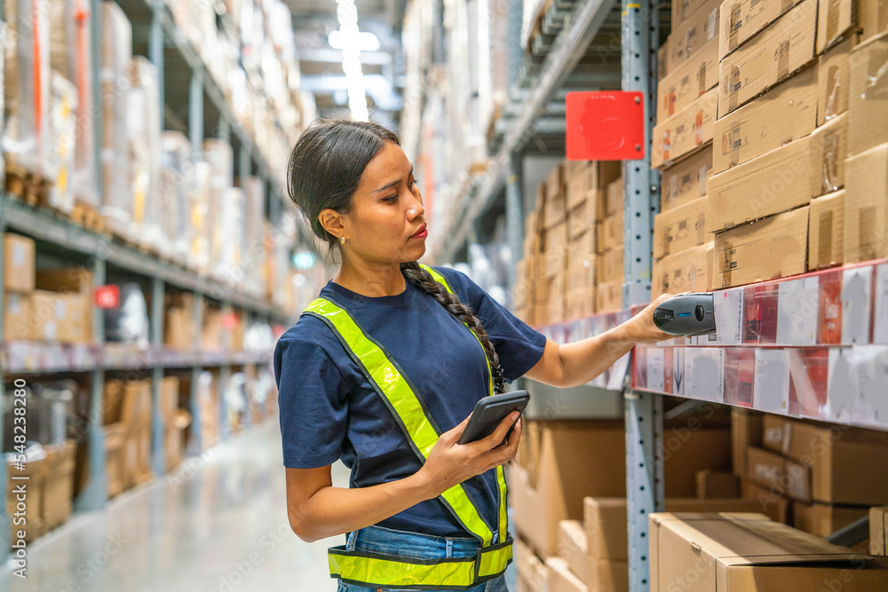 Asian female employees wear reflective safety uniforms, arrange items on shelves and control the quality of wrapping products before delivering to customers in warehouses and wholesale stores. Asian female employees wear reflective safety uniforms, arrange items on shelves and control the quality of wrapping products before delivering to customers in warehouses and wholesale stores.