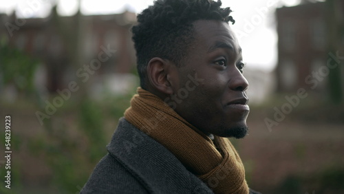 Pensive Young black man walking outside in park nature during winter season
