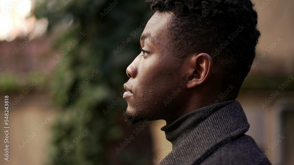 Pensive young black African man standing outdoors Pensive young black African man standing outdoors