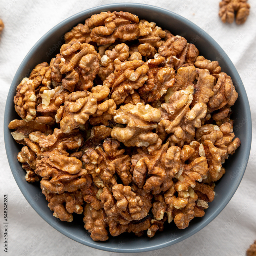 Raw Organic Walnuts in a Bowl, top view. Flat lay, overhead, from above. Close-up. Raw Organic Walnuts in a Bowl, top view. Flat lay, overhead, from above. Close-up.