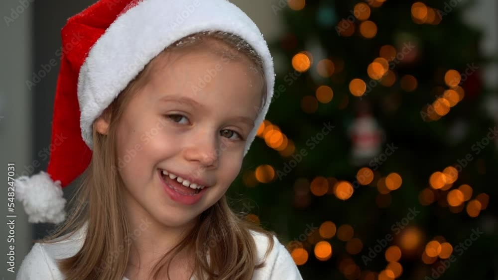 Close up of happy little girl fun throws snow on background of Christmas tree and laughs. New year and christmas. Slow motion Close up of happy little girl fun throws snow on background of Christmas tree and laughs. New year and christmas. Slow motion