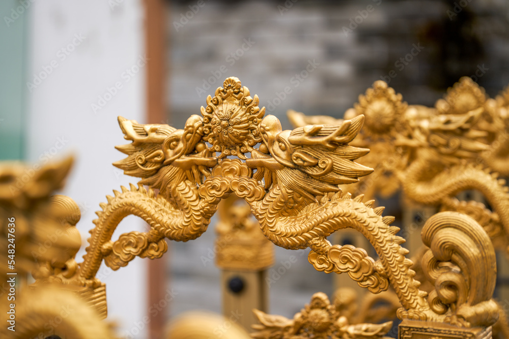 Fototapeta premium Close-up of retractable iron gate carved with golden dragon pattern