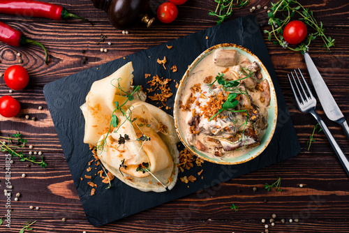 Country-style machanka with ribs, mushrooms, thin pancakes with microgreens and sauce. photo