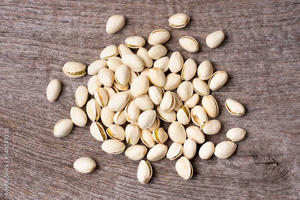 Group of Pistachio nuts isolated on wooden table background. Top view. Flat lay.