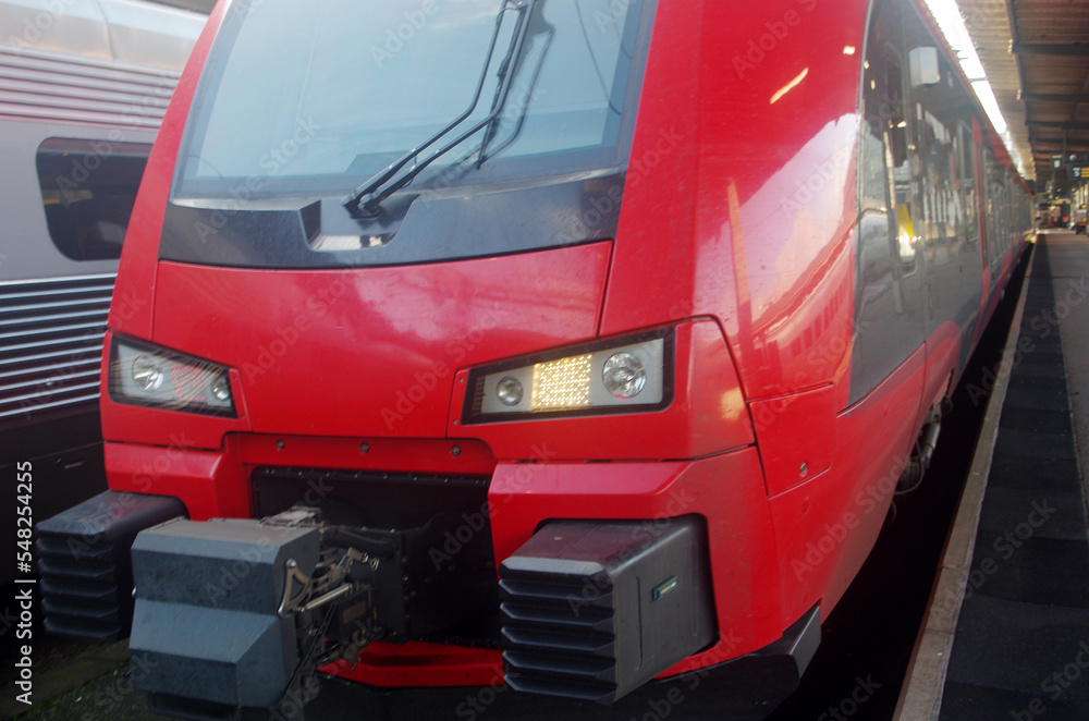 Red electric train near the platform. Close-up. 