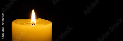 a burning candle on the black backgrounds