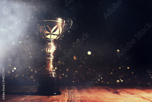 Print op canvas image of gold trophy with sparkly overlay over dark background
