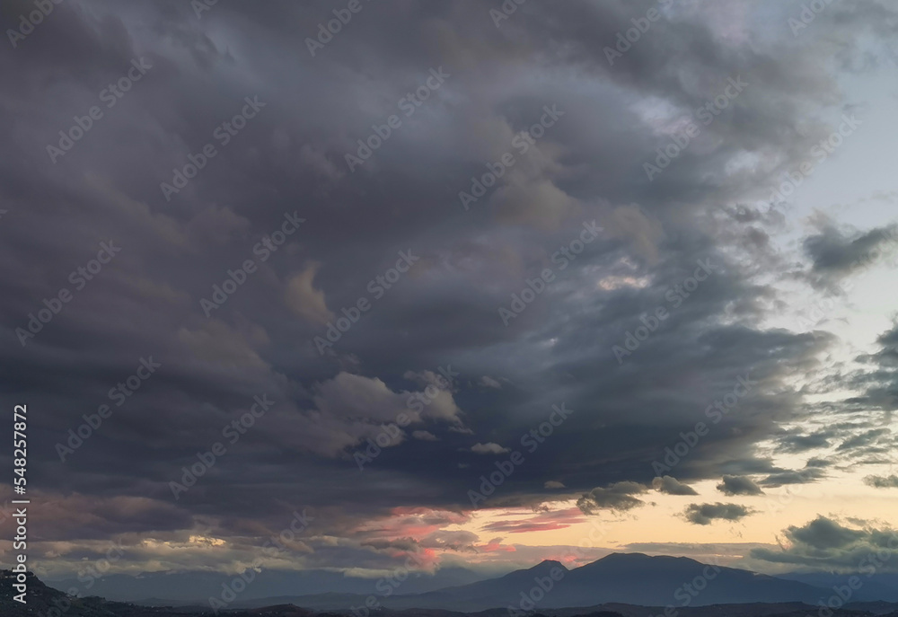 Nuvole enormi e colorate al tramonto sopra le montagne le colline e le valli degli Appennini