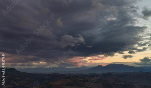 Nuvole enormi e colorate al tramonto sopra le montagne le colline e le valli degli Appennini © GjGj