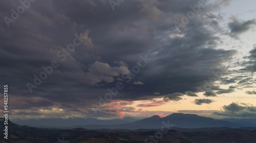 Nuvole enormi e colorate al tramonto sopra le montagne le colline e le valli degli Appennini © GjGj