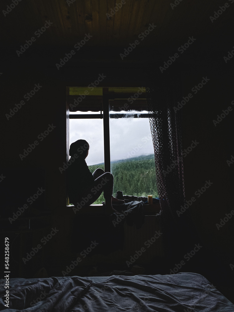 the girl is sitting on the windowsill the girl is sitting on the windowsill