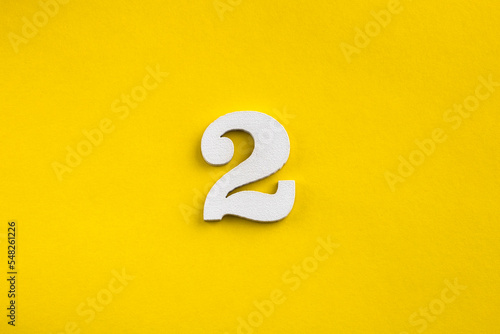 Number 2 - White wooden number on yellow background