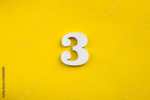 Принти на полотні number three - white number in wood on yellow background