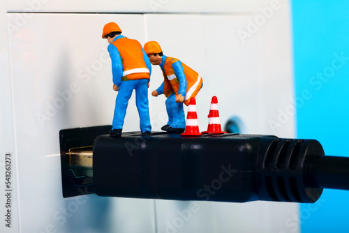 Miniature workmen inspecting an HDMI television socket and plug interface photo