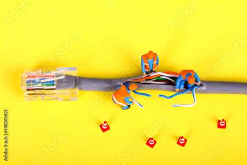 Conceptual image of miniature figure workmen investigating a fault on a broadband network cable
