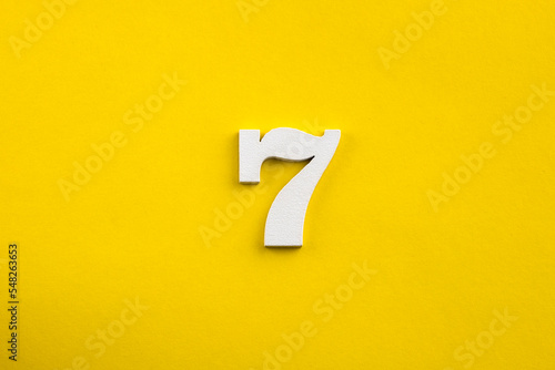 Obraz na plátně Number seven - white number in wood on yellow background