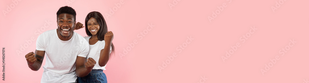 Emotional african american man and woman celebrating success on pink Emotional african american man and woman celebrating success on pink