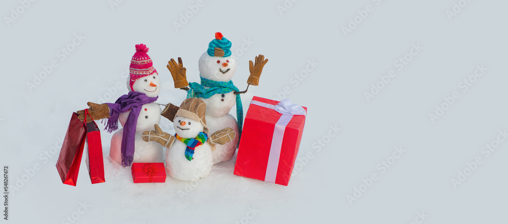 Naklejka premium Snowman with Christmas gift. Merry Christmas and happy new year greeting card with copy space. Snowman banner.