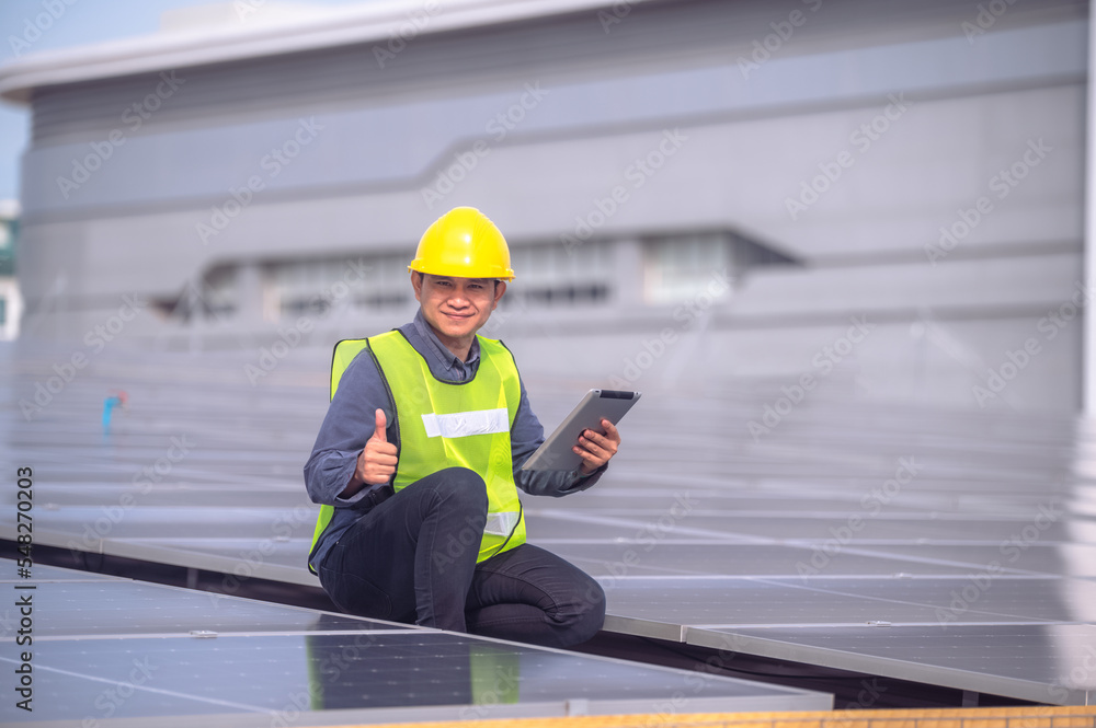 Asian Engineer checking solar power cell energy on rooftop of factory. Asian worker working install solar power solar cell system for using clean solar energy. Asian Engineer checking solar power cell energy on rooftop of factory. Asian worker working install solar power solar cell system for using clean solar energy.