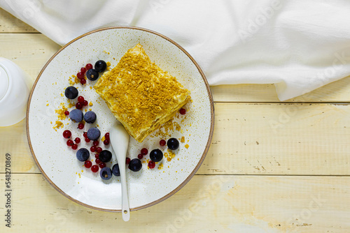 Napoleon cake with berries on a wooden table