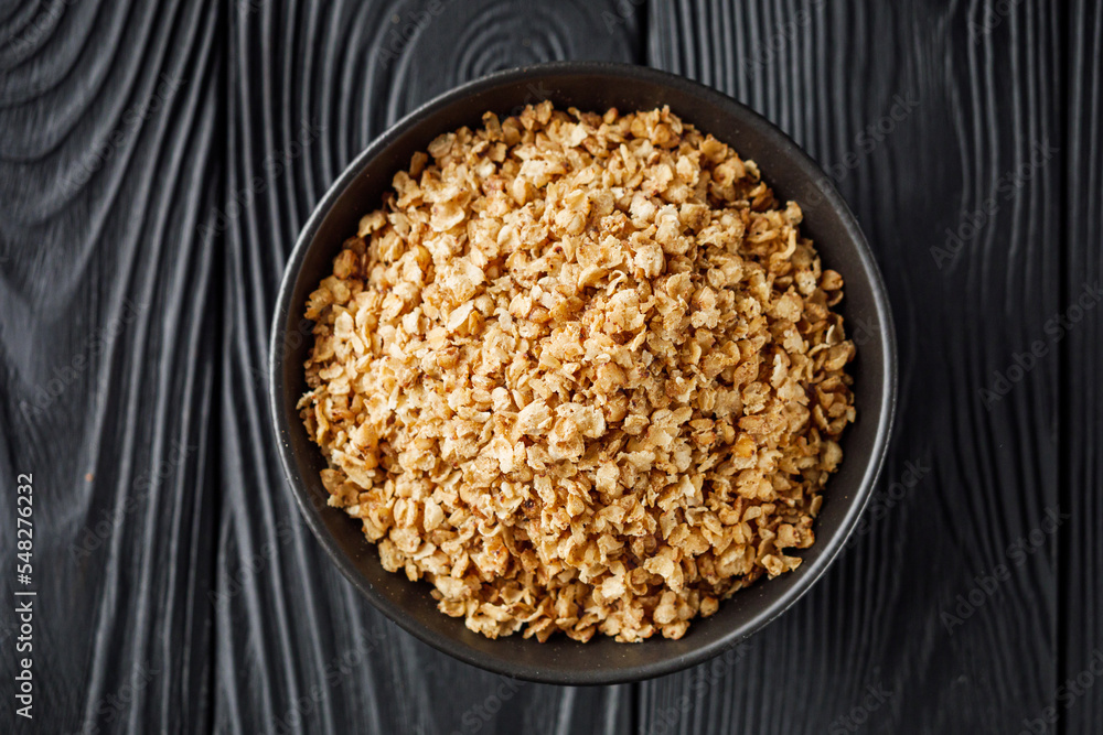 fresh raw buckwheat flakes on a black wooden background fresh raw buckwheat flakes on a black wooden background