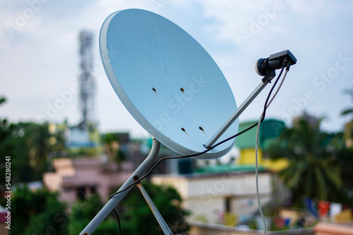 Satellite dish antenna on top of the building in urban area at daytime.. photo