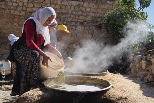 Boiling grape molasses in a cauldron
