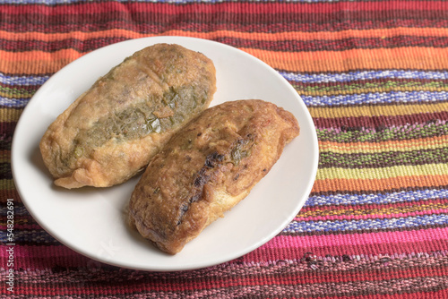 Chiles rellenos.... plato típico guatemalteco hecho con chile guaque relleno de carne de cerdo y verduras picadas como papa, zanahora ejote y rebosado luego en huevo batido y fritos photo