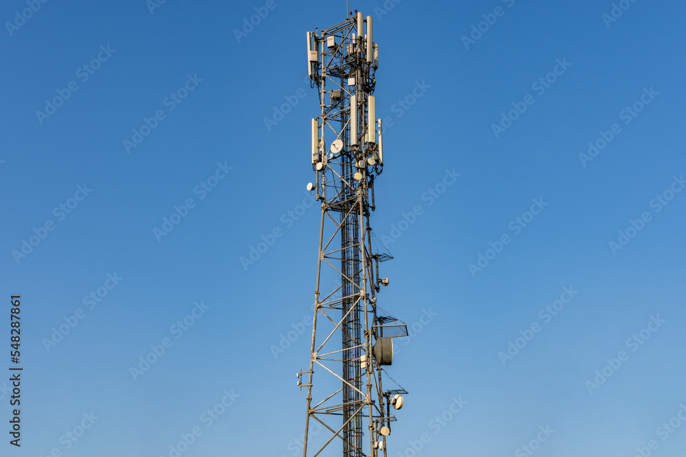 5G antenna communication tower with dish against a clear blue sky 5G antenna communication tower with dish against a clear blue sky