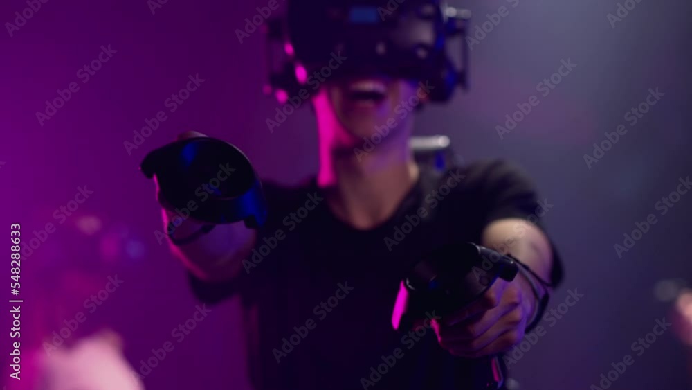 Boy playing VR games in a studio with blue pink neon lights Boy playing VR games in a studio with blue pink neon lights