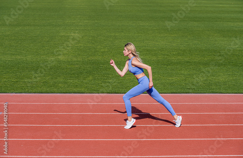 Professional sportswoman during running training session. Woman on stadium track. Sportswoman wearing sportswear. Sportswoman, sportswear. Sportswoman exercising in sport clothing, training, workout