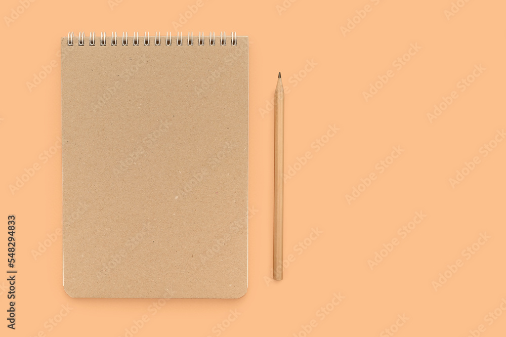 Beige working notebook and pencil for notes on a beige background. Place for text. Beige working notebook and pencil for notes on a beige background. Place for text.