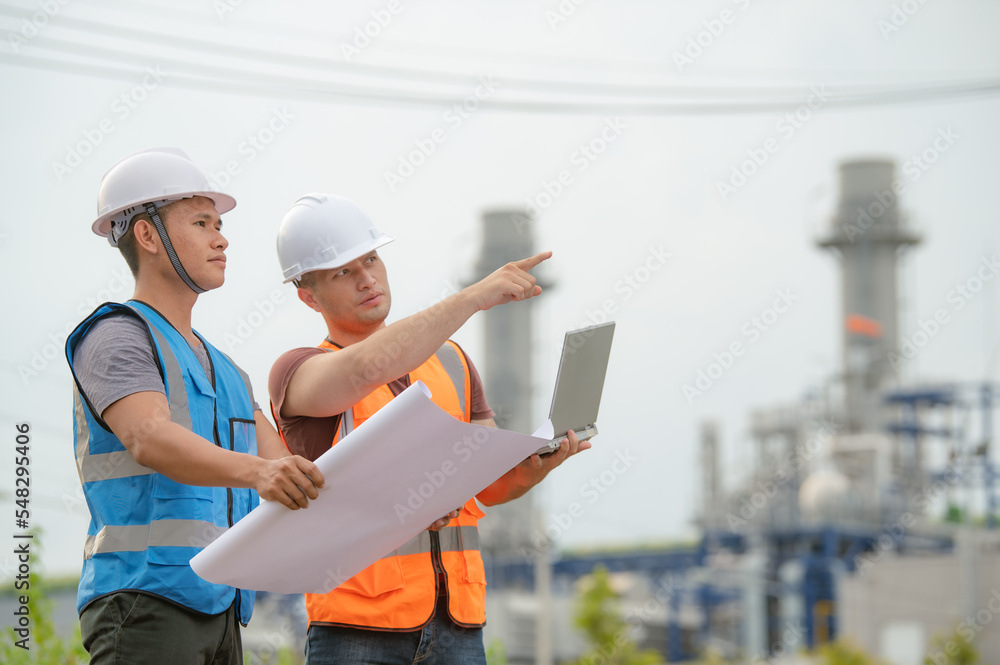 Fototapeta premium Two engineer working at power plant,Work together happily,Help each other analyze the problem,Consult about development guidelines