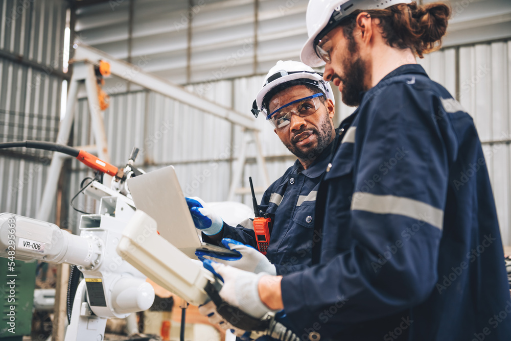Specialist robotic engineers maintenance and control robot arm in factory  warehouse, Testing new innovation automation robot for industrial.African  american and caucasian man teamwork working together Stock Photo | Adobe  Stock