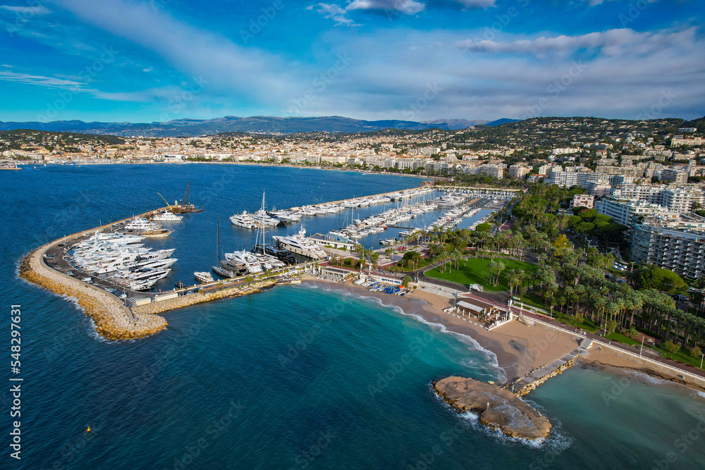 Aerial view of the marina of Cannes full of Yachts with la Croisette and La Plage Du Festival in the background