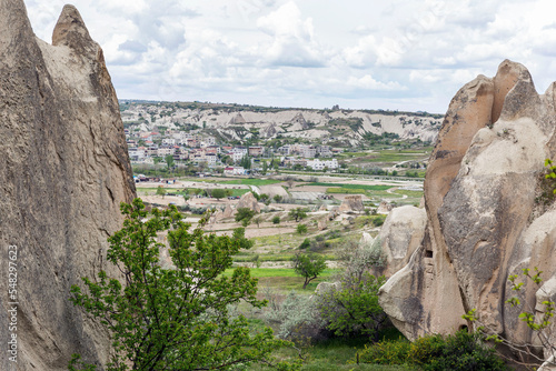 Fototapeta Naklejka Na Ścianę i Meble -  Rocks with caves and city view in a valley in Cappadocia. Magnificent landscape.
