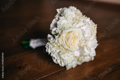 Wedding bouquet of the bride. A beautiful bouquet of white flowers and greenery lies on the table.