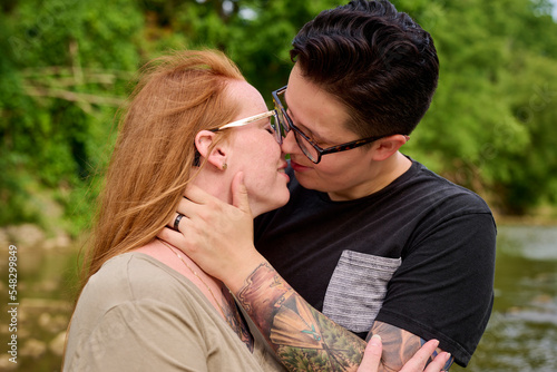 Same sex female couple kissing outdoors.