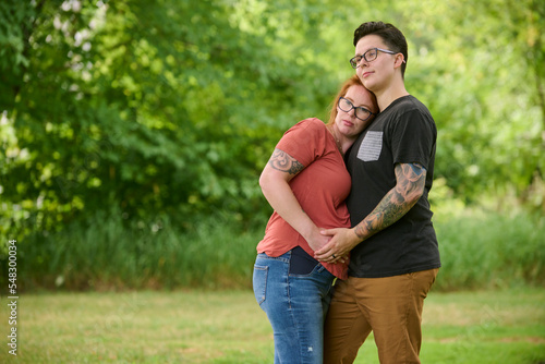 Same sex couple embracing outdoors.