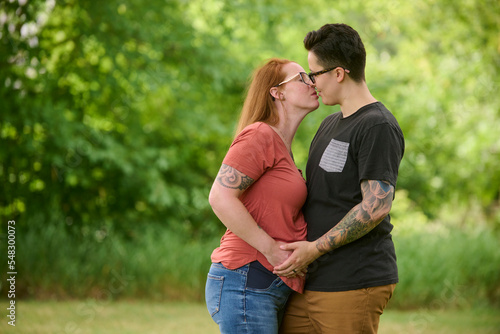 Same sex couple kissing outdoors.