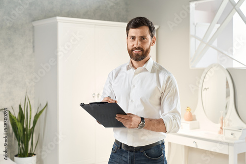 Εκτύπωση καμβά Professional retailer standing with clip-on tablet, while smiling at camera in exhibition center