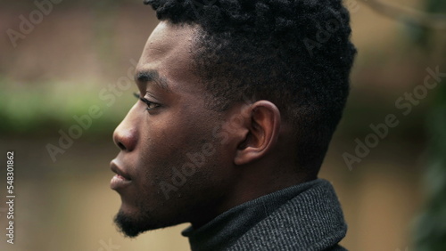 Serious young black African man no emotion expression staring camera, tracking face shot