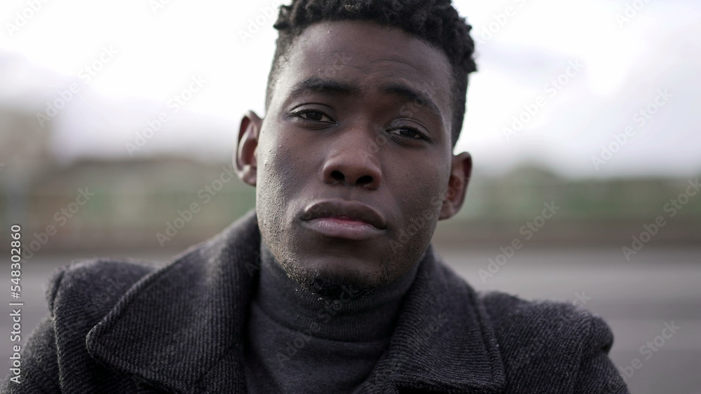 Serious black African man looking at camera portrait in urban city setting Serious black African man looking at camera portrait in urban city setting