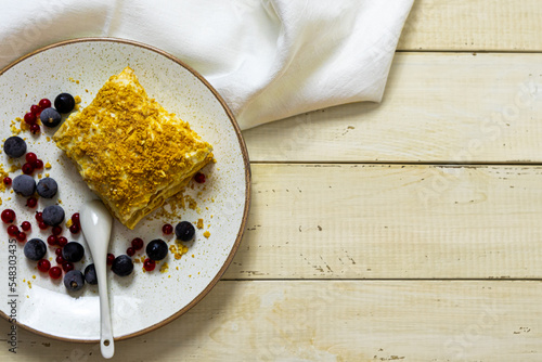 Napoleon cake with berries on a wooden table