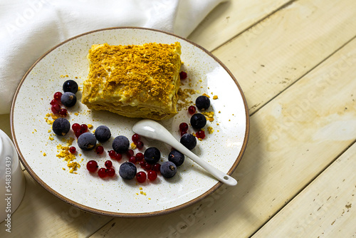 Napoleon cake with berries on a wooden table