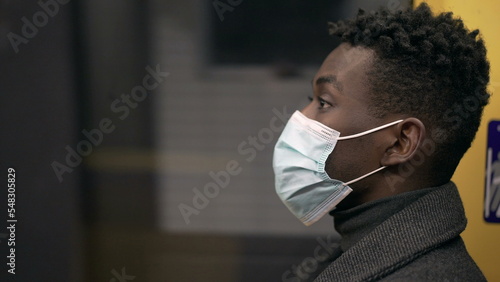 Profile of black African man wearing covid-19 face mask inside subway metro