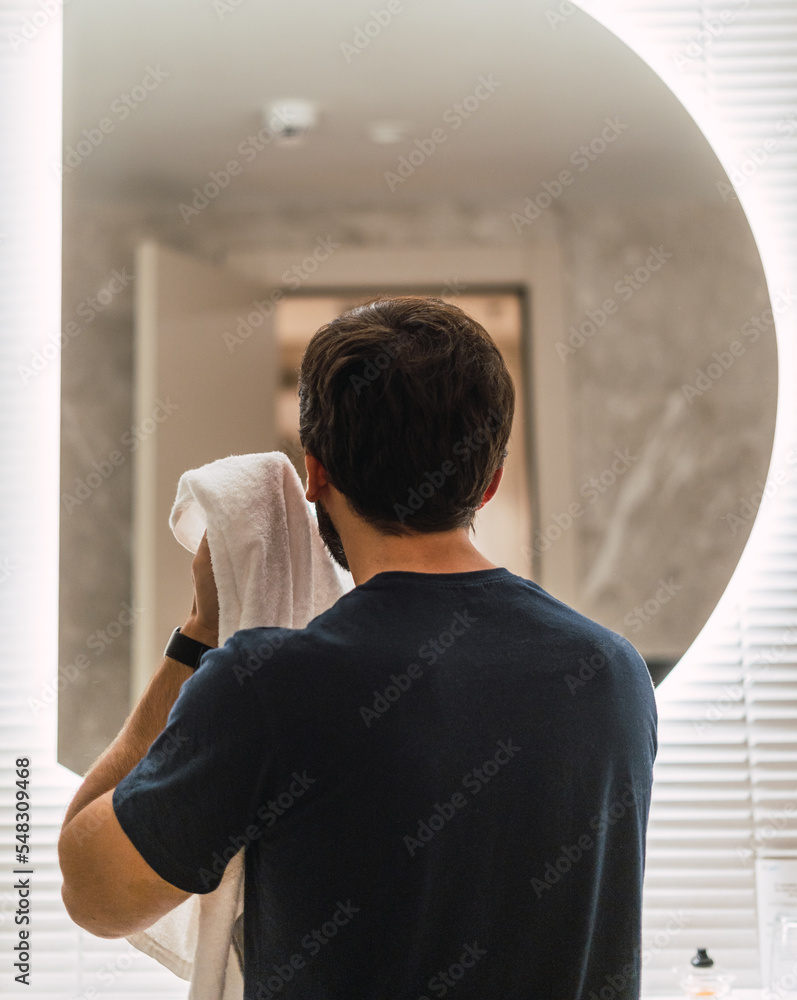 Fototapeta premium Man cleaning his face in the bathroom. facial care