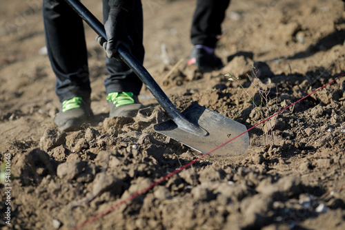 Wallpaper Mural Details with a person shovelling dry, arid and dusty soil during a planting activity. Torontodigital.ca