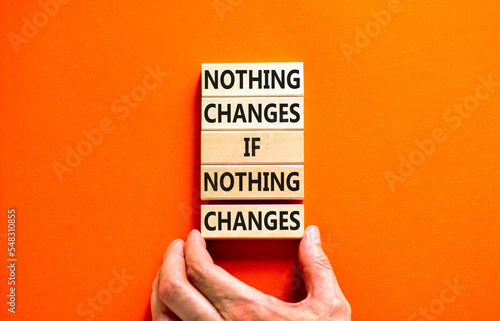 Nothing change symbol. Concept words Nothing changes if nothing changes on wooden blocks. Businessman hand. Beautiful orange table orange background. Business nothing changes concept. Copy space.